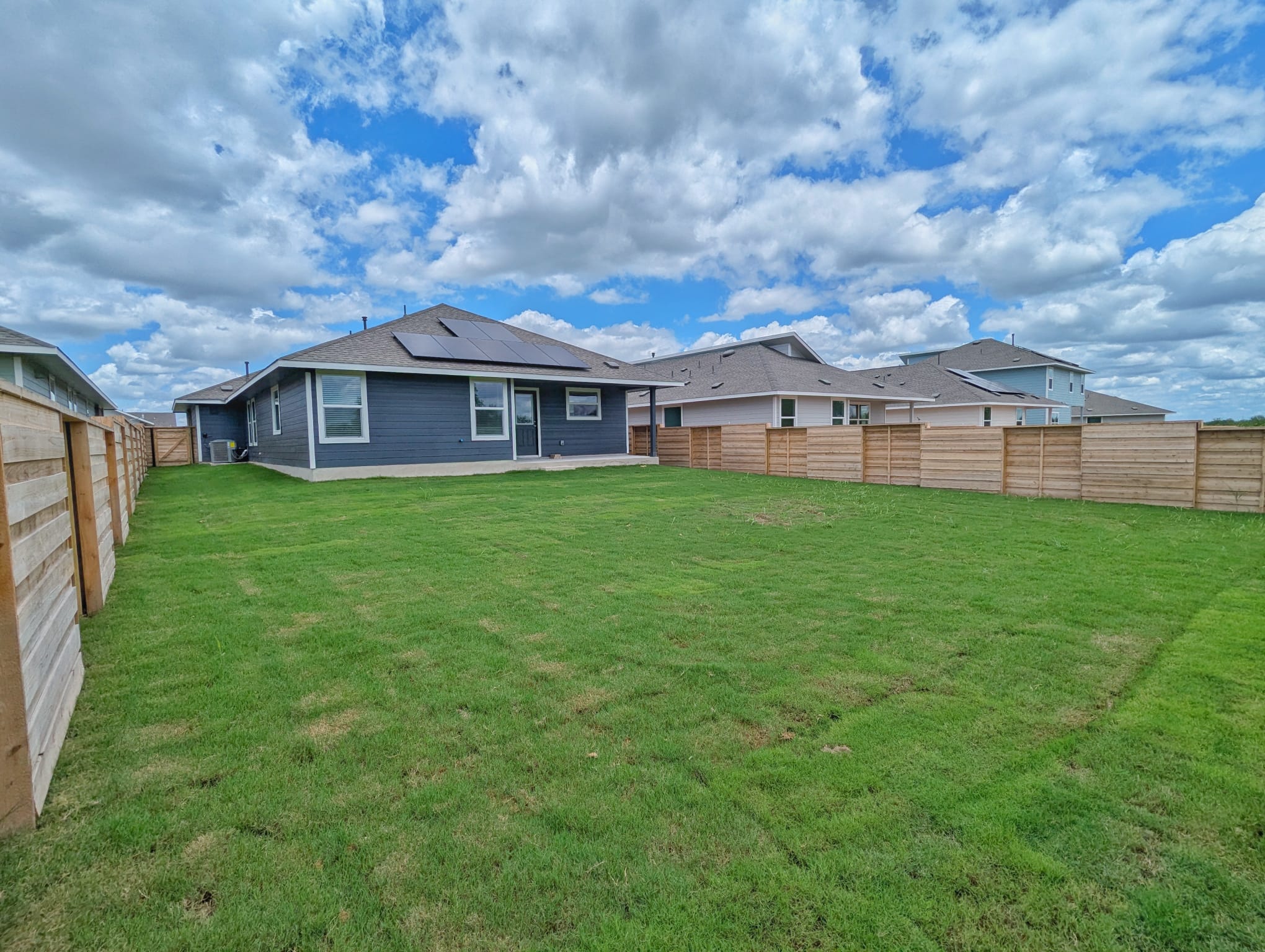1504 Marley Kyle, TX 78640 - Photo 26 of 28 Back of house featuring solar panels and a fenced backyard
