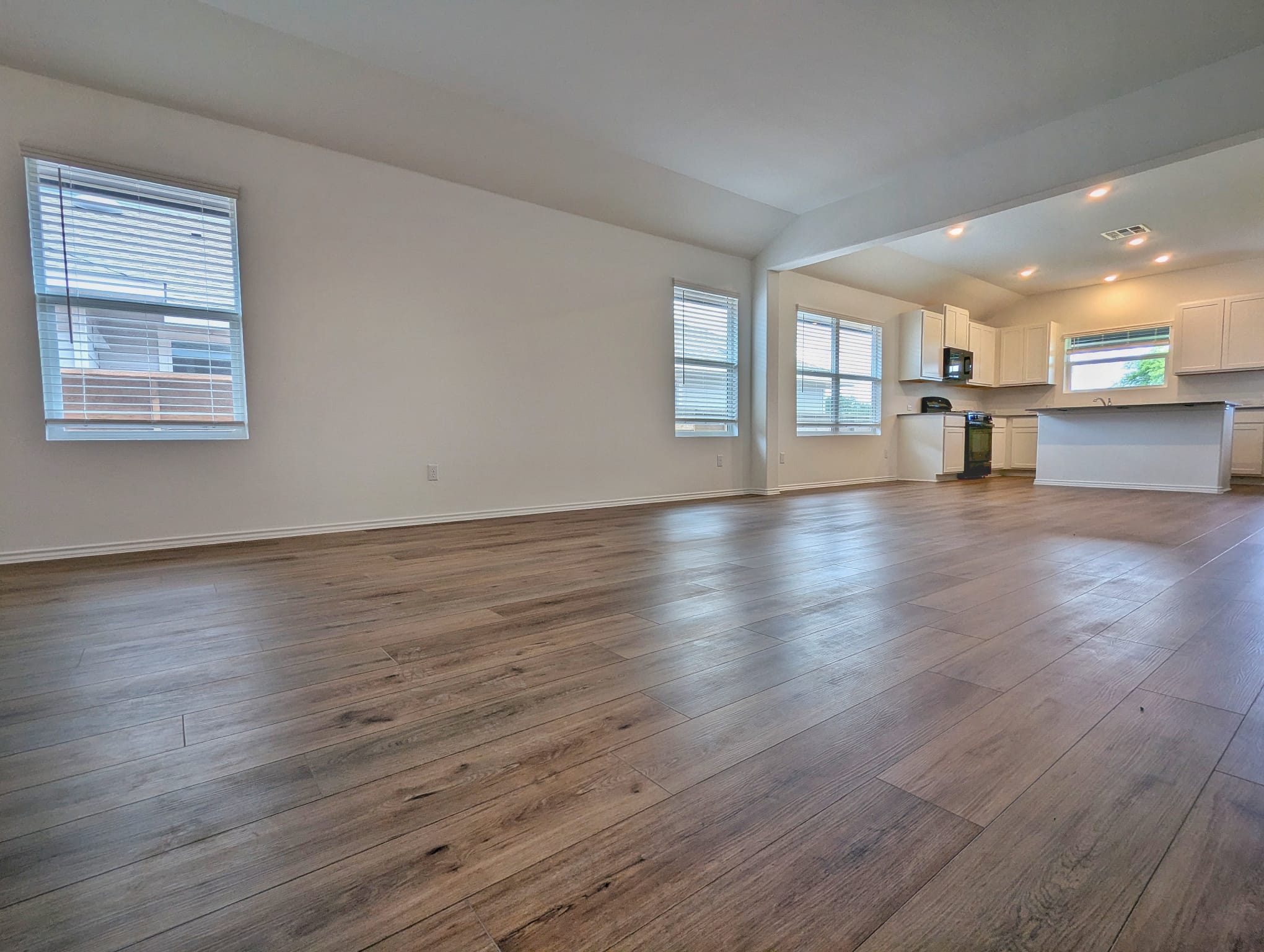 1504 Marley Kyle, TX 78640 - Photo 7 of 28 Unfurnished living room featuring lofted ceiling, dark wood-type flooring, and recessed lighting