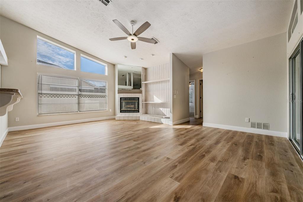 5315 Saltamonte Drive New Port Richey, FL 34655 - Photo 5 of 26 an empty room with wooden floor fireplace and windows