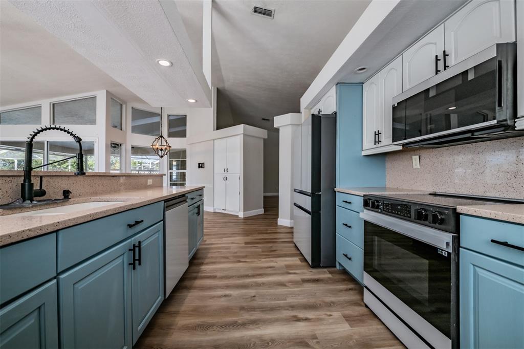 5315 Saltamonte Drive New Port Richey, FL 34655 - Photo 6 of 26 a kitchen with stainless steel appliances a stove microwave and sink