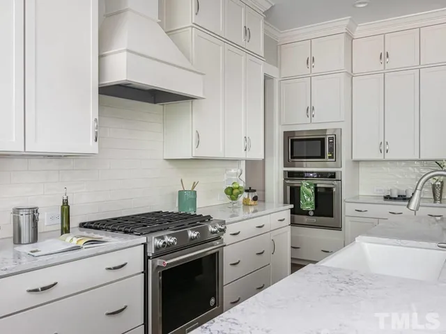 a kitchen with white cabinets stainless steel appliances and sink