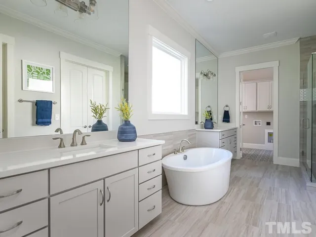 a bathroom with a white tub sink and mirror