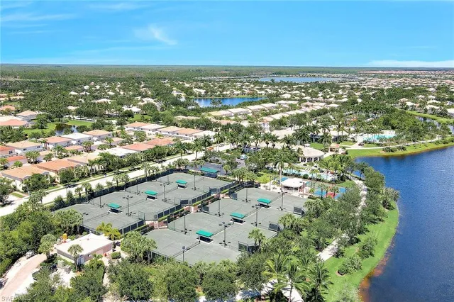 an aerial view of residential houses with outdoor space and lake view