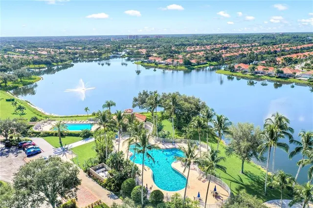 an aerial view of ocean and residential houses with outdoor space