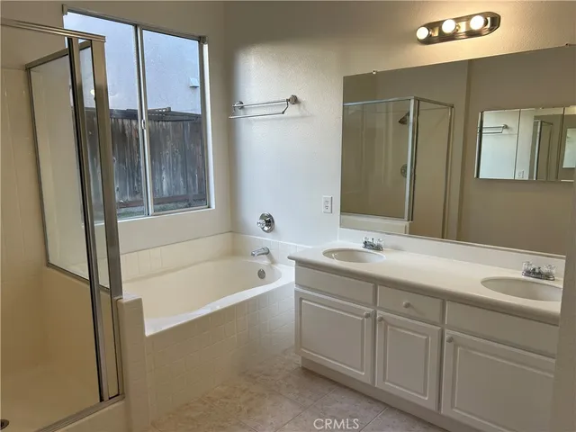a bathroom with a tub sink and mirror
