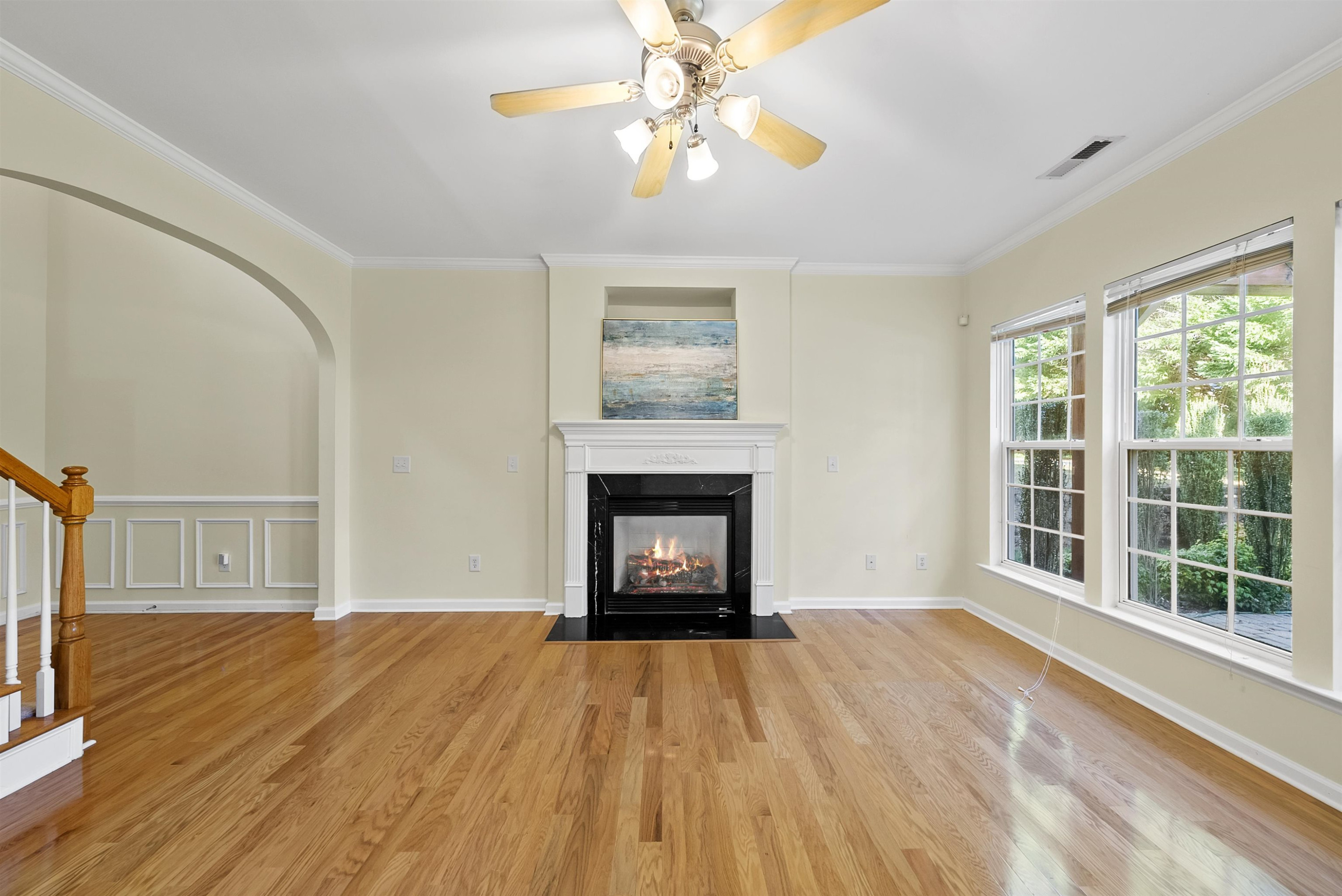 8408 Tie Stone Way Raleigh, NC 27613 - Photo 6 of 33 a view of an empty room with wooden floor fireplace and a window