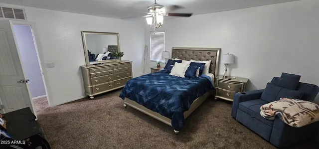 a spacious bedroom with a bed and a chandelier