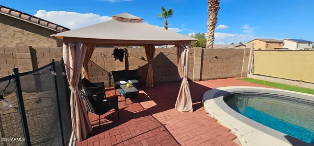 a view of a patio with a table and chairs under an umbrella