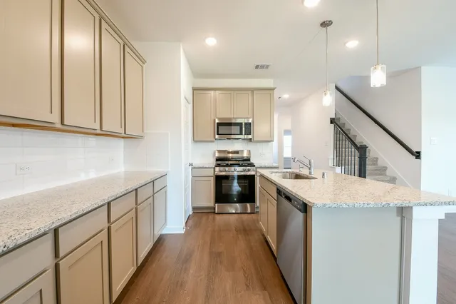 a kitchen with a stove top oven and sink