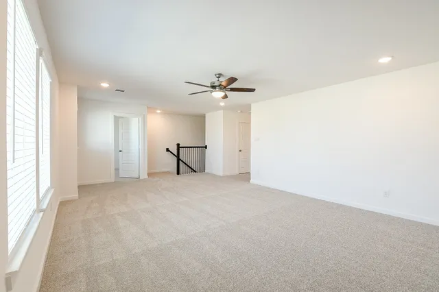 an empty room with a window and a ceiling fan