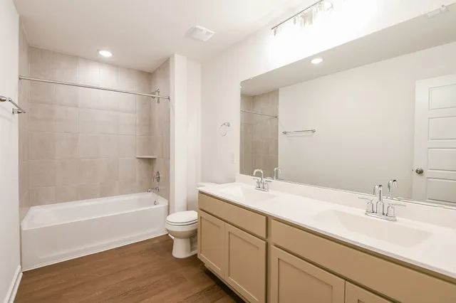 a bathroom with a tub a sink shower and a toilet