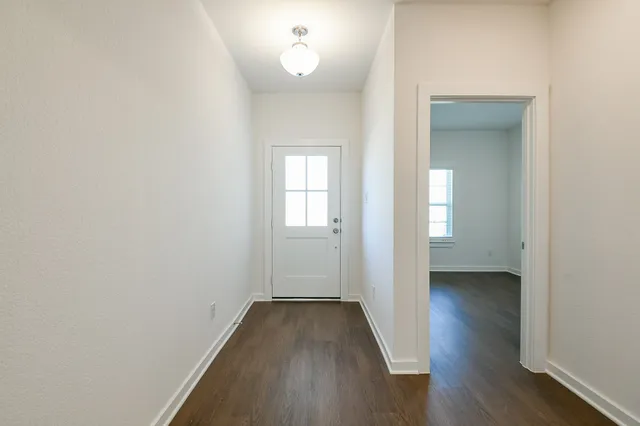 a view of a room with wooden floor and a window