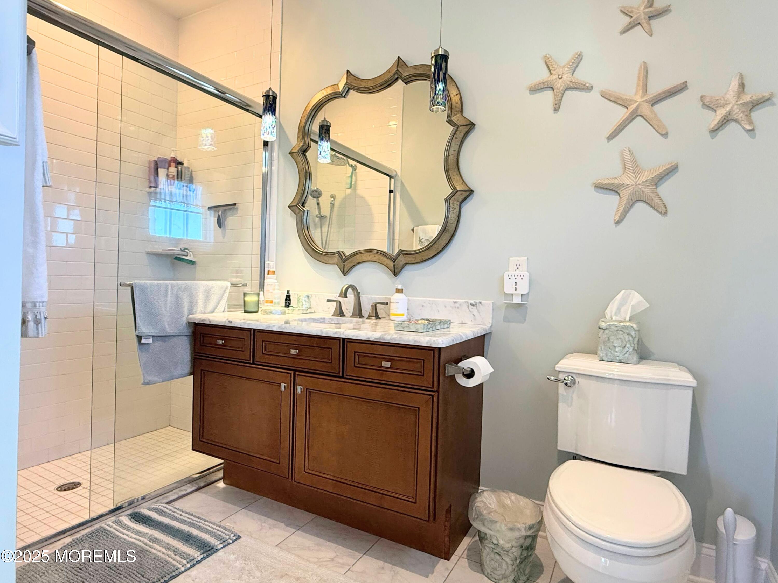 2 Main Street, Unit 308 Bradley Beach, NJ 07720 - Photo 18 of 31 a bathroom with a toilet a sink and mirror
