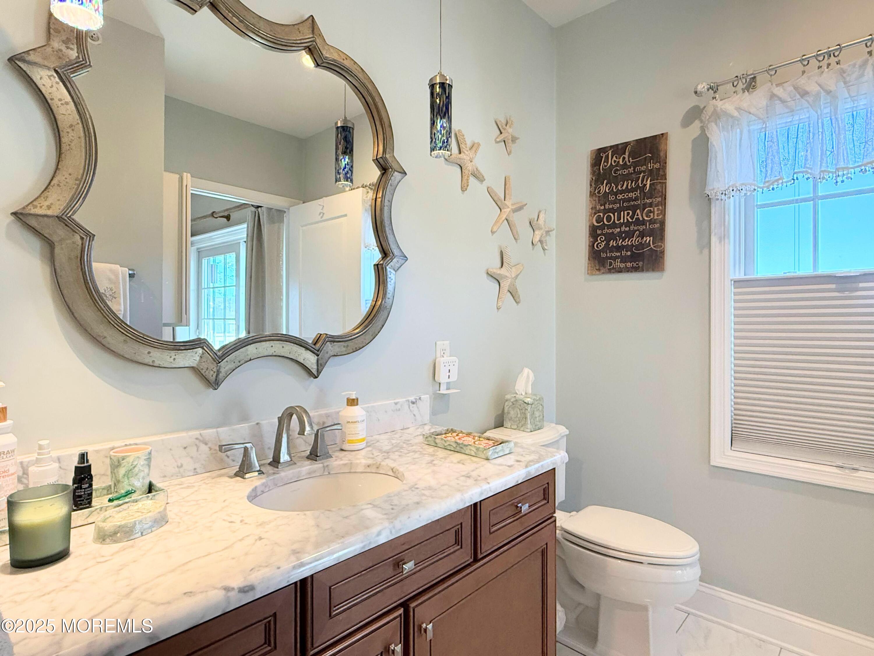 2 Main Street, Unit 308 Bradley Beach, NJ 07720 - Photo 19 of 31 a bathroom with a granite countertop sink a toilet and a mirror