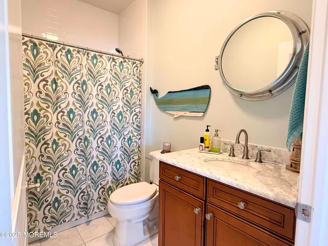a bathroom with a granite countertop toilet sink and mirror