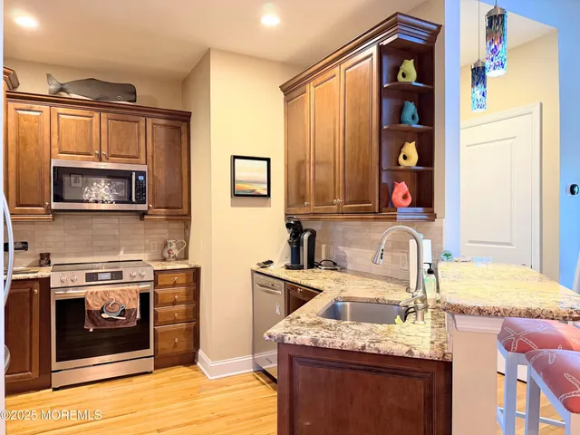 a kitchen with stainless steel appliances granite countertop a sink stove and microwave