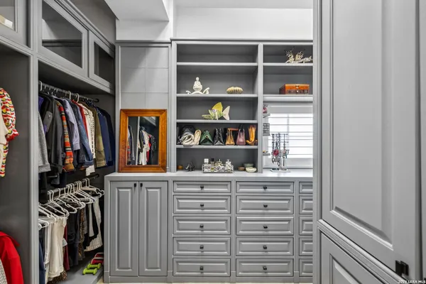 a view of walk in closet with clothes and shoes