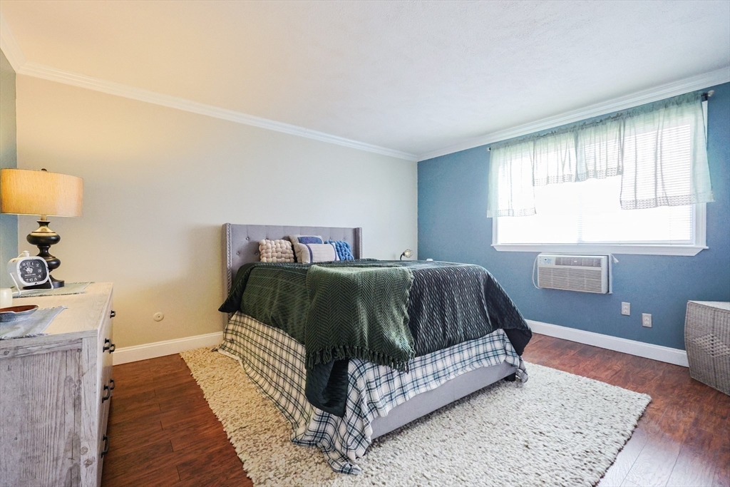 116 Boston Post Road East, Unit 101 Marlborough, MA 01752 - Photo 17 of 34 a bedroom with a bed and wooden floor