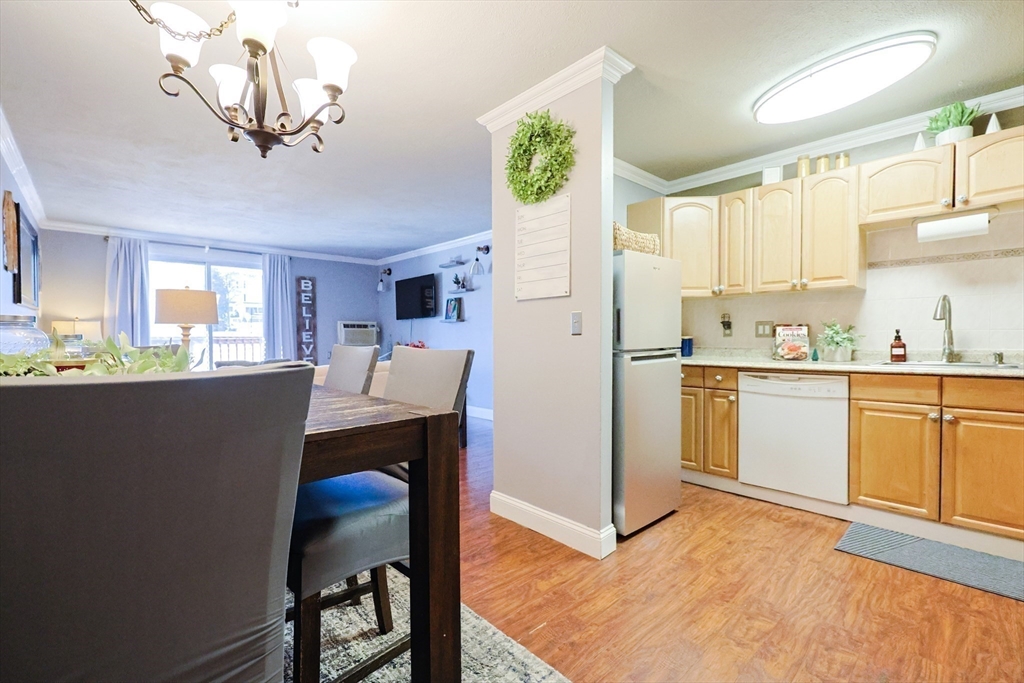 116 Boston Post Road East, Unit 101 Marlborough, MA 01752 - Photo 2 of 34 a kitchen with a table chairs refrigerator and microwave
