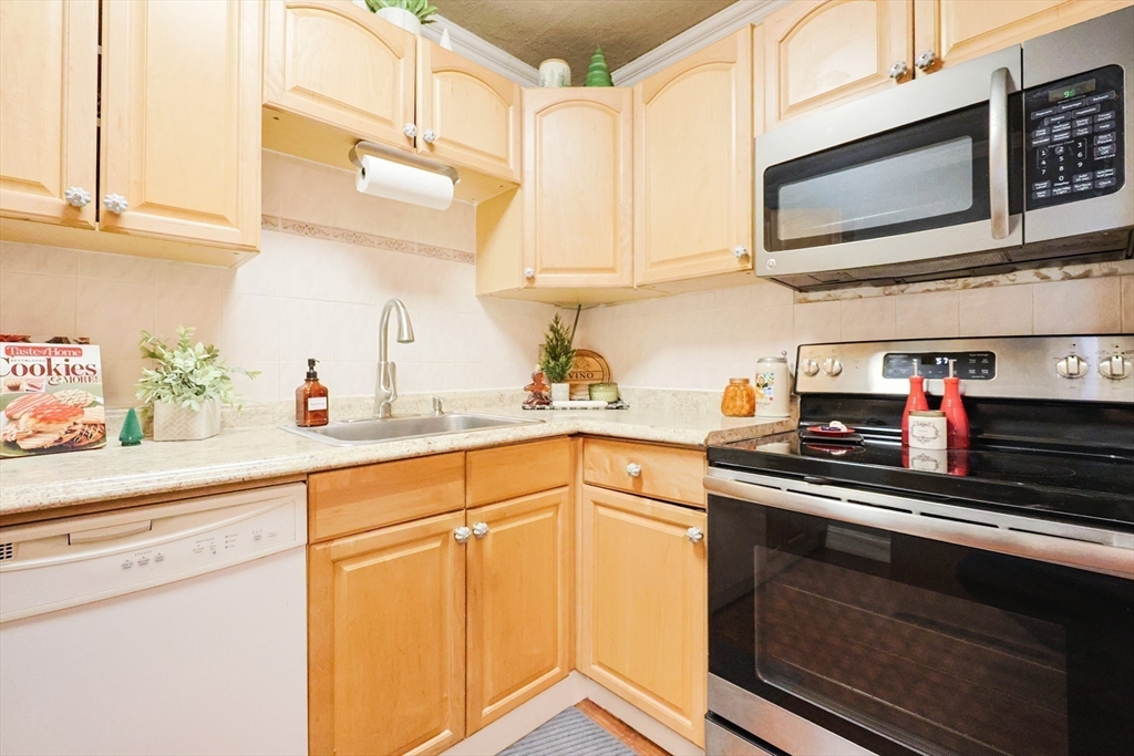 116 Boston Post Road East, Unit 101 Marlborough, MA 01752 - Photo 6 of 34 a kitchen with stainless steel appliances granite countertop a sink and cabinets