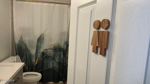 a bathroom with a toilet and a shower