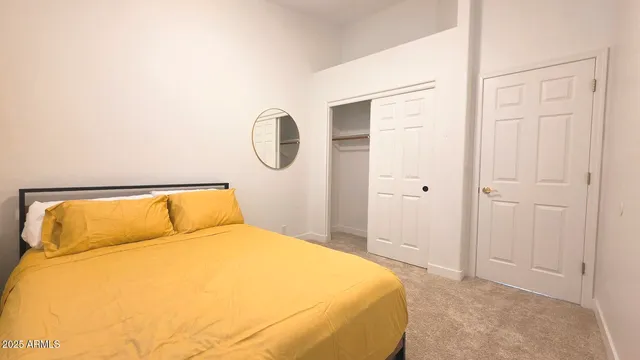 a bedroom with a bed and a painting on the wall