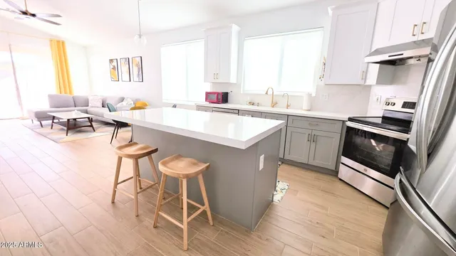 a kitchen with stainless steel appliances a stove a sink dishwasher and cabinets with wooden floor