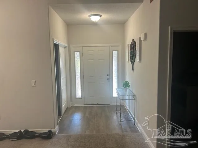 a view of a hallway with wooden floor and a bathroom
