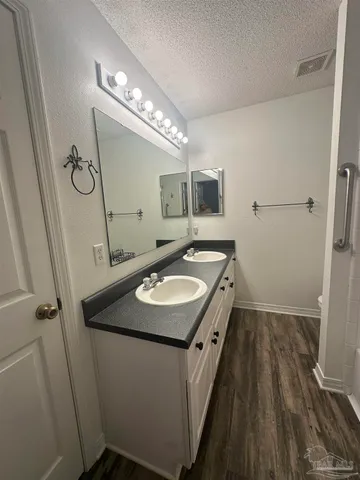 a bathroom with a sink and mirror with bathtub