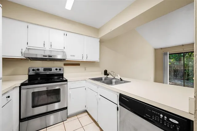 a kitchen with granite countertop white cabinets and white appliances