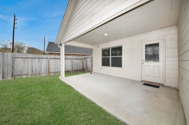 a view of a house with backyard and wooden fence