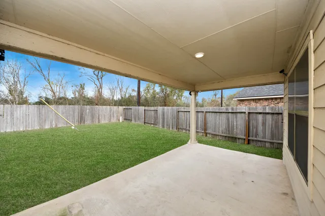 a view of a backyard with wooden fence