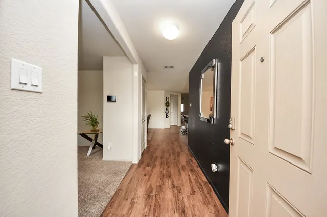 a view of a hallway with wooden floor and staircase