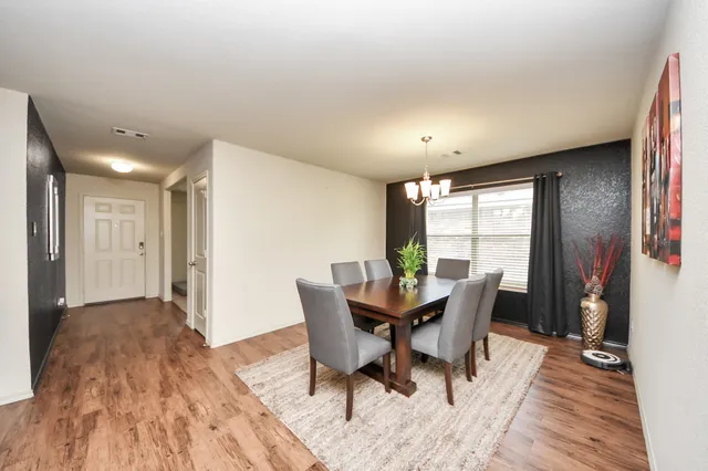 a dining room with furniture and wooden floor