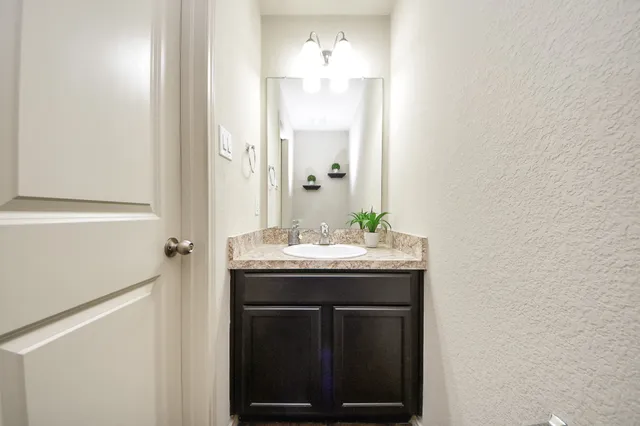 a bathroom with a granite countertop sink and a mirror