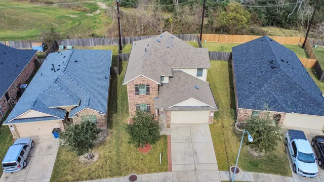 an aerial view of a house with a garden and large trees