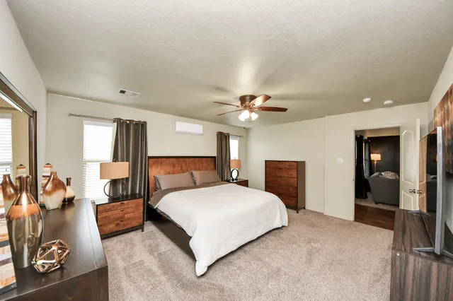 a bedroom with a large bed and a chandelier