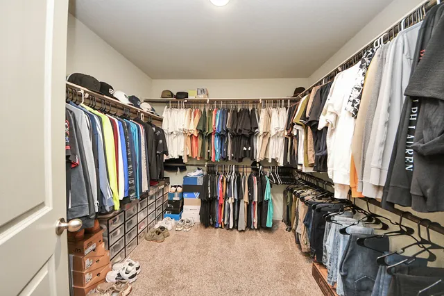 a view of walk in closet with clothes