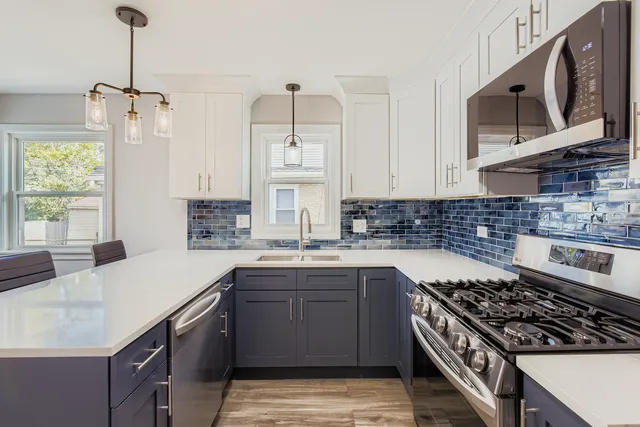 a kitchen with stainless steel appliances a sink stove and cabinets