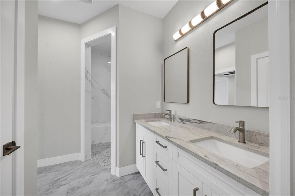 9 Bunker Place Rotonda West, FL 33947 - Photo 21 of 36 a bathroom with a granite countertop sink double and mirror