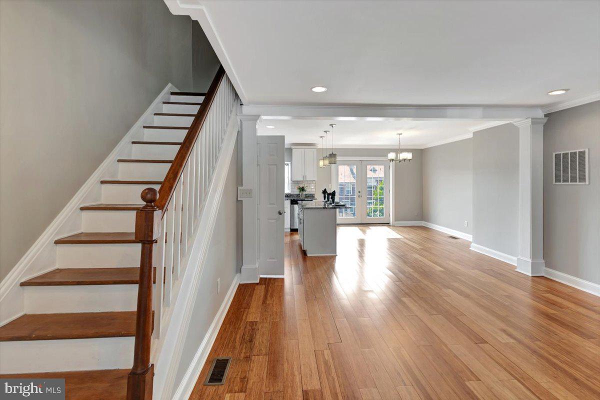 3927 Yolando Road Baltimore, MD 21218 - Photo 5 of 50 a view of a hallway with wooden floor kitchen view and a chandelier