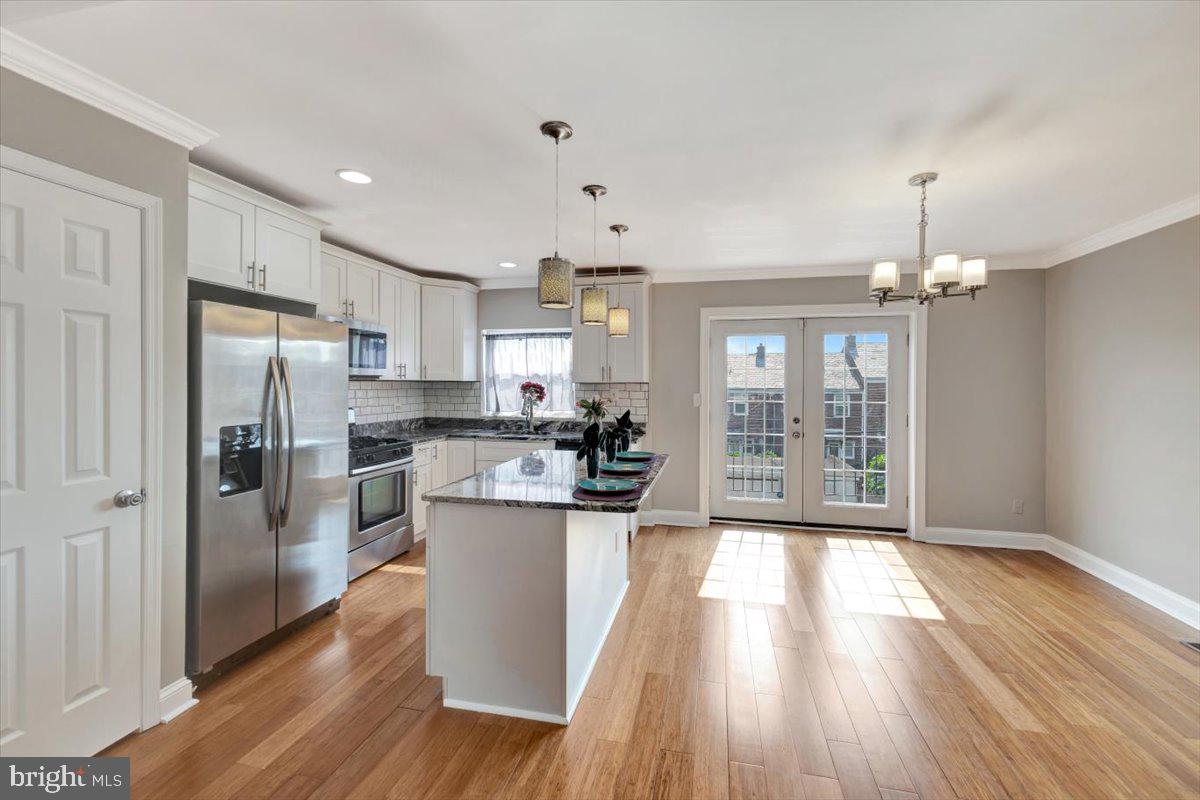3927 Yolando Road Baltimore, MD 21218 - Photo 9 of 50 a kitchen with stainless steel appliances a refrigerator a stove top oven and wooden floors
