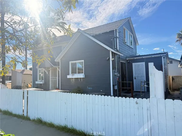 a view of a house with a wooden fence