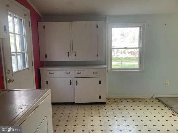 a kitchen with granite countertop white cabinets and window