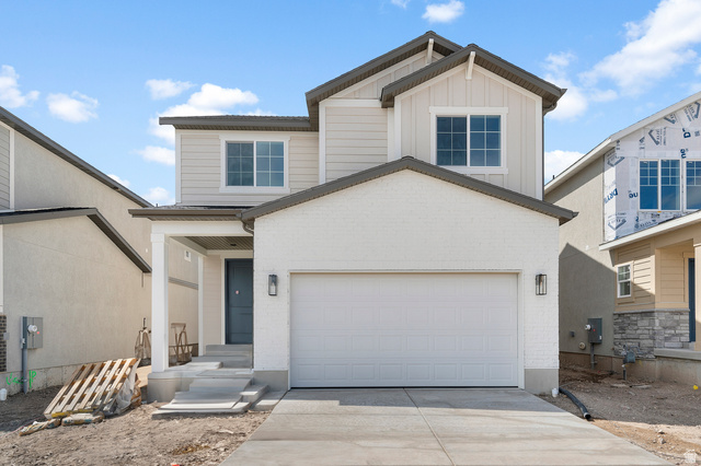 7797 West Alta Springs Way Magna, UT 84044 - Photo 1 of 21 View of front of property with board and batten siding, concrete driveway, a garage, and brick siding