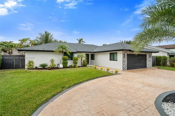 a patio with a table and chairs and potted plants