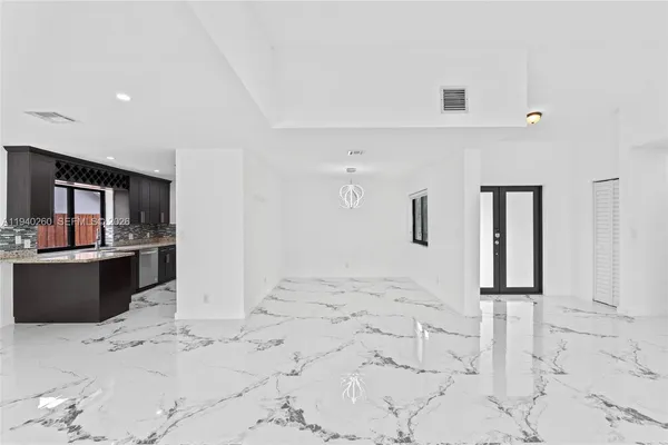 a view of kitchen with stainless steel appliances kitchen island sink refrigerator and microwave