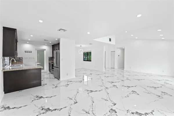a view of a hallway with wooden floor and a window