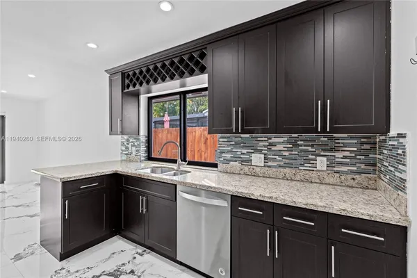 a kitchen with stainless steel appliances granite countertop a sink and a stove