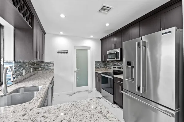 a kitchen with a refrigerator sink and microwave